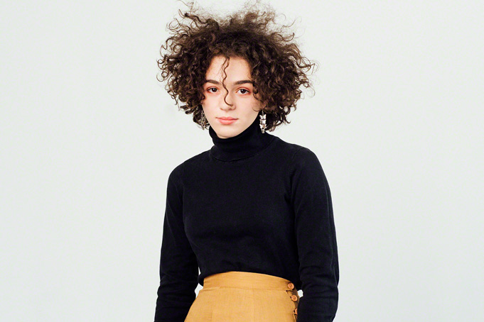in studio portrait, beautiful young girl with curly unruly hair, simple and classic