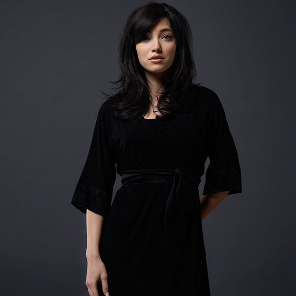 striking in studio portrait of a young woman against dark background