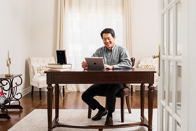 Great-West Life Insurance, on location shot of wealthy client in home office reviewing investment on ipad, corporate