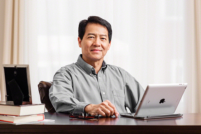 Great-West Life Insurance, on location portrait of well to do client sitting a desk at home, beautiful light