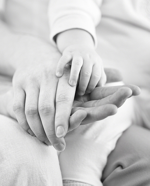 pharmaceutical company Amgen, Enbril drug, natural light black and white shot, baby's hand gently touching parents hands, brochure