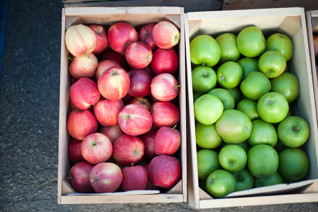freshly picked crate of green and red apples ready for market, editorial