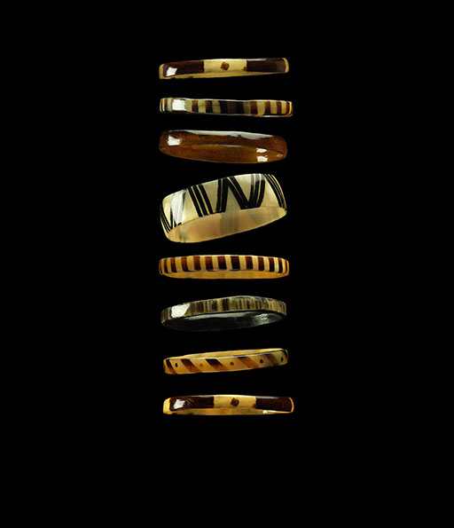 graphic shot of a series of bracelets floating on black, fashion editorial, accessories, product photo