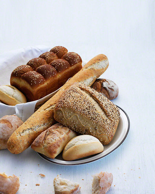 editorial, cover shot of bread varieties on white background, natural light, food photograph