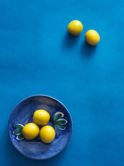 overhead shot of kumquats on blue background, graphic food photo, editorial