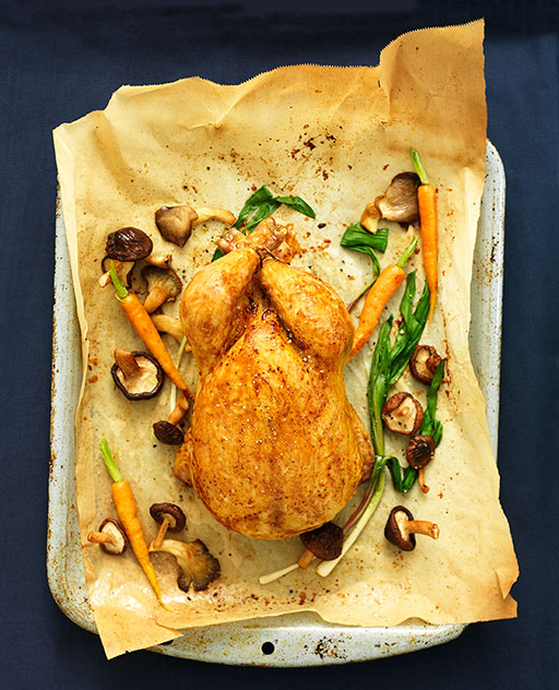 overhead shot of roasted chicken and vegetables on rich background, editorial