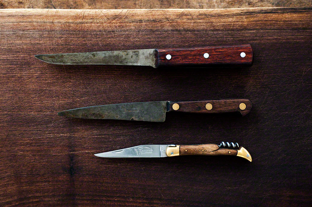 overhead shot of three antique knives with wooden handles on wooden surface, stil life, advertising