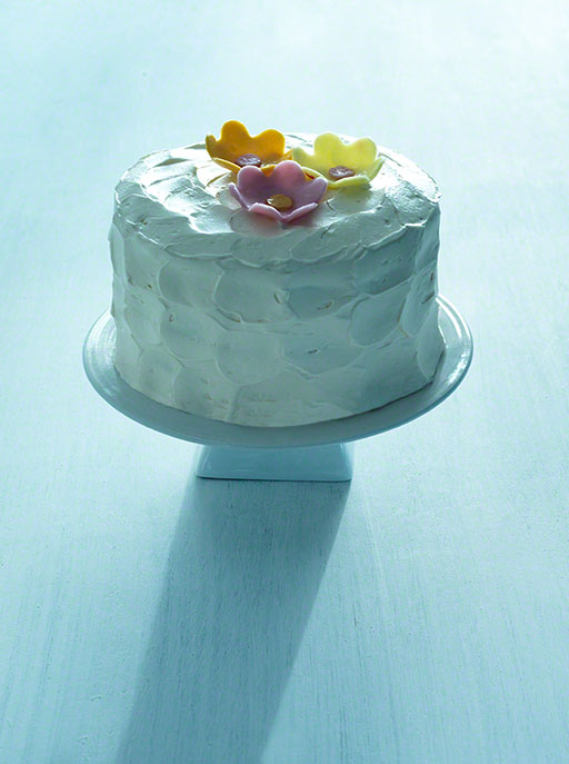 graphic, food shot of a vanilla cake with iced flowers editorial