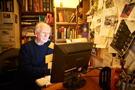 Environmental portrait of author Howard Engels at home in his office