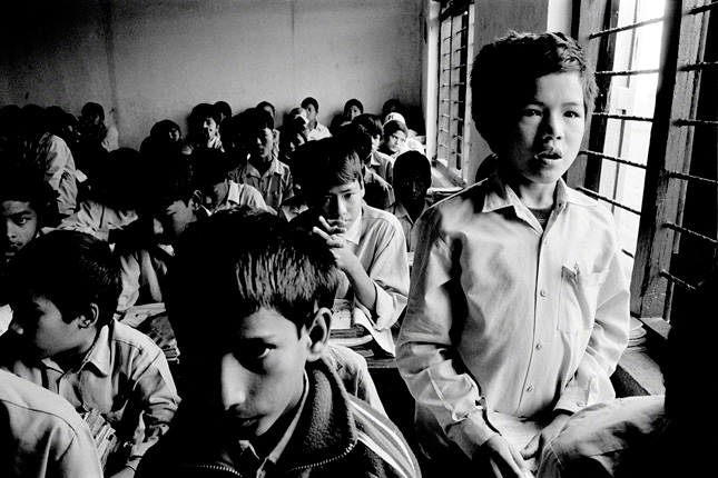 nepalese student standing while reciting in his all boys class 