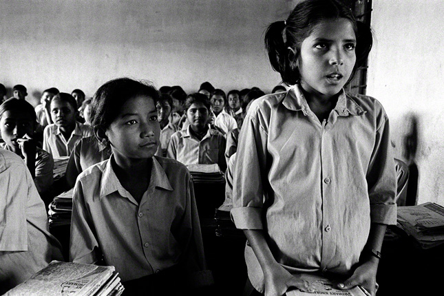 middle school aged girl standing in class answering question