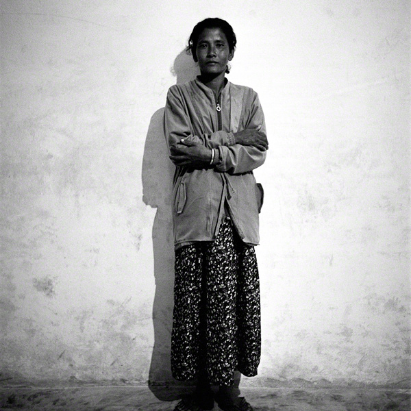 portrait of woman against plain concrete wall